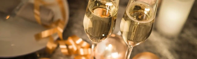 Due calici di champagne su un tavolo con decorazioni festive.